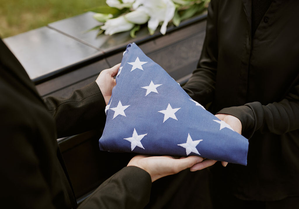 Hands Present Folded Flag at Funeral Service